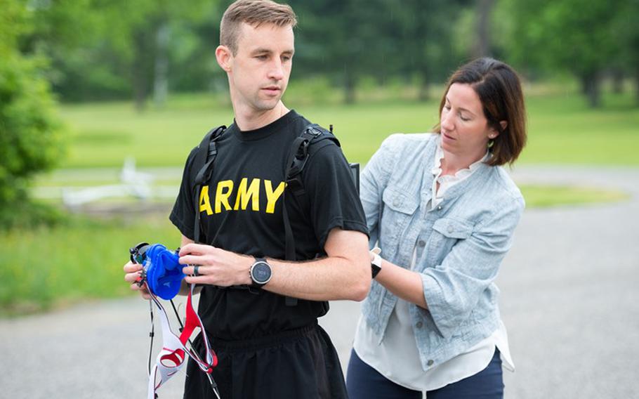 Megan Amadeo, Army Wellness Center Project Officer, Army Public Health Center, assists U.S. Army Capt. Zachary Schroeder, Headquarters and Headquarters Company commander, Army Public Health Center, with putting on the new K5 metabolic testing unit May 9, 2019, as part of his training to compete in the Army Ten Miler in Oct. 2019. (Photo Credit: Graham Snodgrass)