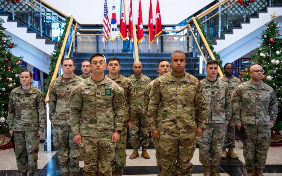 Capt. Franklin Wright, 2nd Infantry Division, and Chief Warrant Officer 2 Marcus Dunmore, 35th Air Defense Artillery Brigade, stand in front of the rest of Eighth Army's 2022 Gen. Douglas MacArthur Leadership Award competitors during a ceremony at USAG Humphreys, South Korea, Dec. 5, 2022. (U.S. Army photo by Cpl. Park, Joon Hyeok)