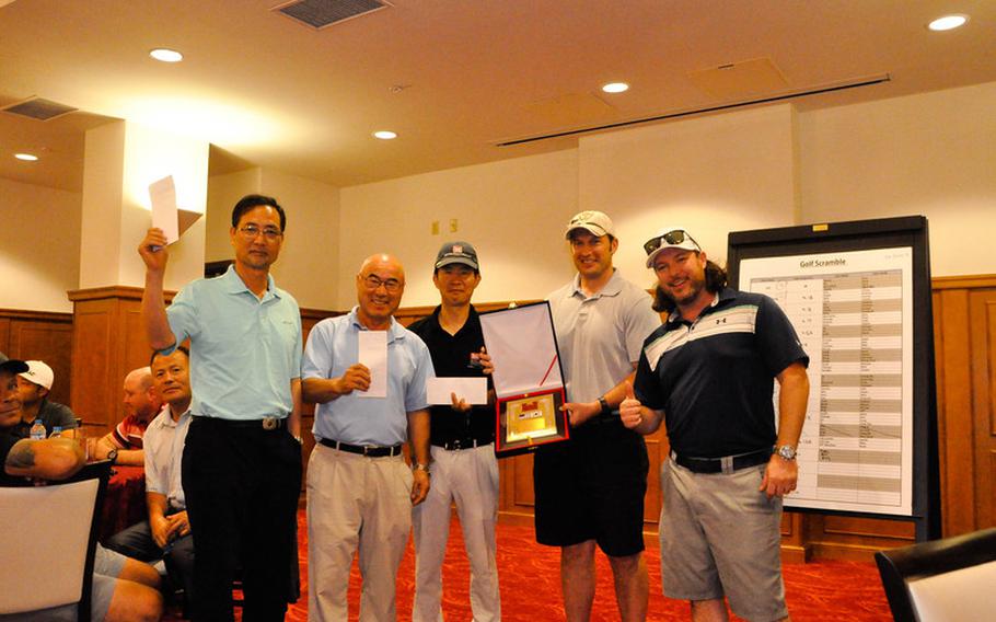 Ross Moore (right), a physical security specialist, stands along with the U.S. Army Corps of Engineers, Far East District, Bi-Annual Golf Tournament winners at the River Bend Golf Course, Camp Humphreys, South Korea, June 26.