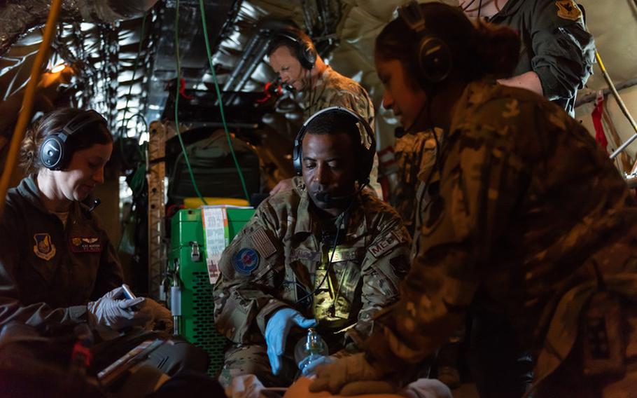 Airmen from the 18th Aeromedical Evacuation Squadron simulate life-saving procedures to a training mannequin onboard a KC-135 Stratotanker during an exercise at Kadena Air Base, Japan, Oct. 8, 2019. The 18th AES deploys and operates elements of a theater aeromedical evacuation system capable of worldwide taskings. (U.S. Air Force photo by Senior Airman Matthew Seefeldt)