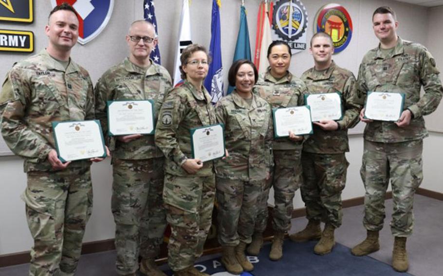 Army Reserve augmentees who supported Headquarters, 403rd Army Field Support Brigade, during the Freedom Shield 23 exercise display their Army Achievement Medal certificates with Col. Lisa Rennard, brigade commander, 403rd AFSB, following an awards ceremony at Camp Henry, South Korea, March 24. (Photo Credit: Galen Putnam)