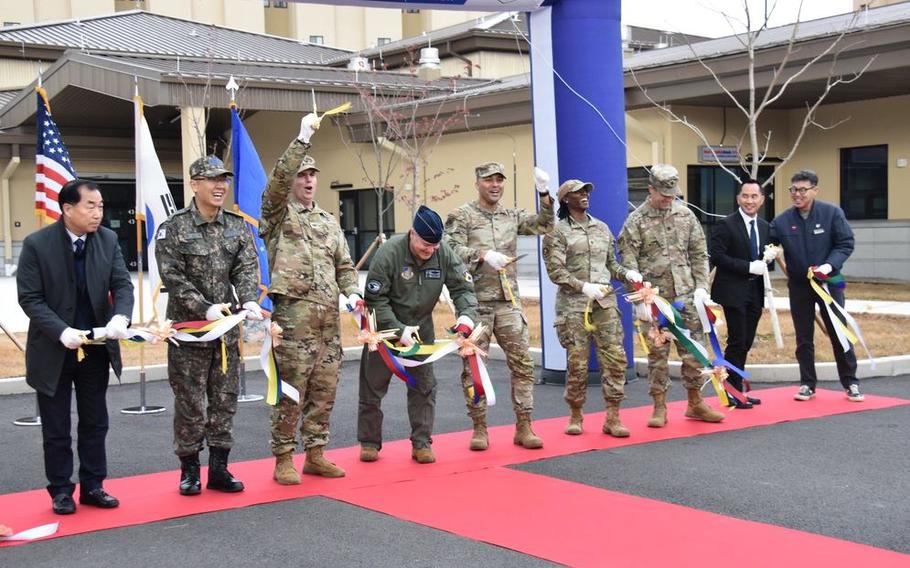 Representatives including Col. Peter Kasarskis (fourth from left), commander, 8th Fighter Wing; Col. Jeremiah Willis (third from left), commander, U.S. Army Corps of Engineers – Far East District; Col. Joshua Hawkins (center), commander, 8th Mission Support Group; and others cut the ribbon the new 39,000 square foot dining facility.