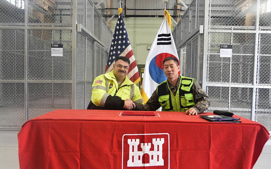 Col. Lee WooSik (right), Chief, Program Management Team, MURO, and Col. Garrett Cottrell (left), Deputy Commanding Officer - Transformation, United States Army Corps of Engineers Far East District, sign the Acceptance Release Letter for the Vehicle Maintenance Facility 120, which will support the 65th Medical Brigade, Camp Humphreys, South Korea, Jan. 30, 2020.