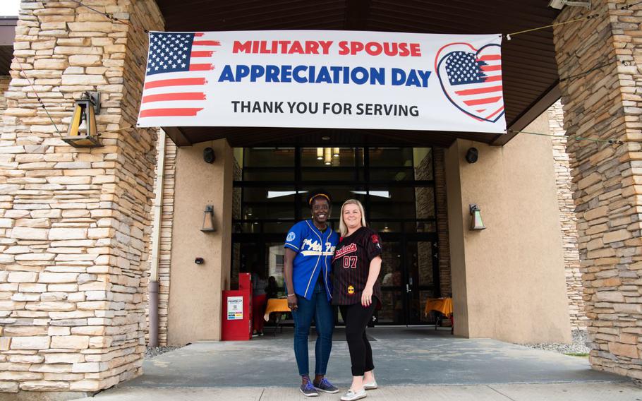 Lt. Col. Martine Doleman, 7th Air Force reservist and military spouse, left, smiles with Sarah Rolin, military spouse beneath a Military Spouse Appreciation Day banner May 6, 2022, at Osan Air Base, Republic of Korea. Military Spouse Appreciation Day is celebrated to acknowledge the significant contributions, support and sacrifices of military spouses. (U.S. Air Force Photo by Senior Airman Allison Payne)