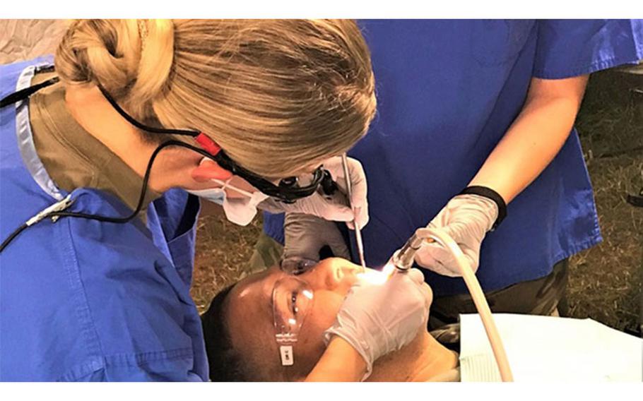 Army dentist, Capt. Cierra Diamse, a general dentist assigned to the Wiesbaden Dental Clinic, performs dental work on a soldier during a field training exercise held recently at Baumholder, Germany. Following the 9 Ways to RUIN Your Dental Fitness assures a scene like this downrange. (U.S. Army photo by Kirk Frady)