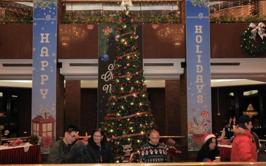 U.S. Soldiers, civilians, distinguished guests, and family members gather to celebrate the holiday season during an annual tree lighting ceremony at the Dragon Hill Lodge, Yongsan, South Korea.