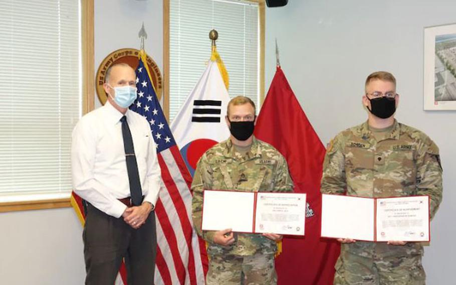 Mr. Richard T. Byrd, FED Deputy District Engineer, presents ENFIRE instructors Staff Sgt. William Lack and Spc. Christopher Bowden of the 11th Engineers with certificates of achievement.