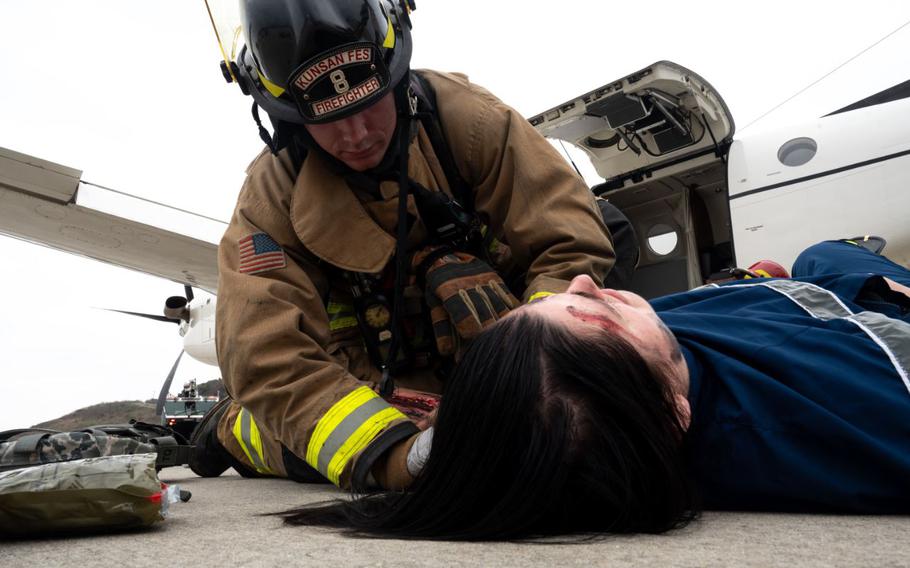 A firefighter from the 8th Civil Engineer Squadron attends to a simulated victim during a mass accident response exercise at Kunsan Air Base, Republic of Korea, April 4, 2024. MAREs allow Airmen to practice their emergency response skills for potential real-world incidents or accidents.