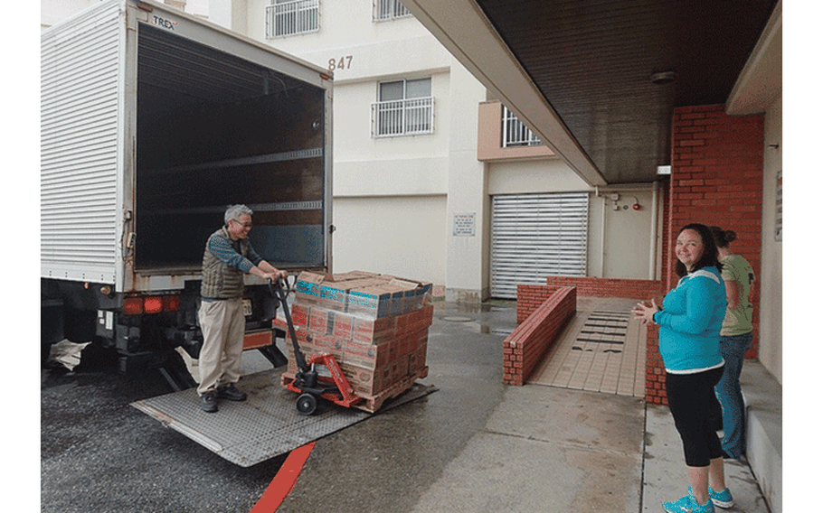 Sakumoto Toshiro, tracker-trailer driver for the Okinawa Distribution Center, unloads boxes of Girl Scout cookies for expectant Girl Scouts volunteers. The Exchange has supported the Girl Scouts for more than 20 years by shipping cookies to overseas military installations in time for their annual selling season.