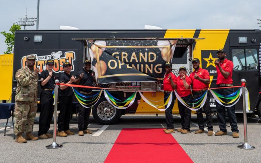 Members of the Culinary Outpost food truck gather for a photo before the start of the grand opening ceremony at Camp Humphreys.