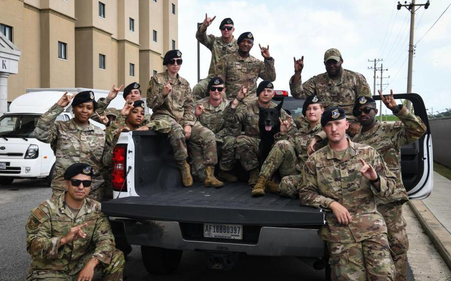 Defenders with the 8th Security Forces Squadron take a group photo with military working dog Alan before his final salute at Kunsan Air Base, Republic of Korea, July 22, 2022. Alan was born on June 22, 2012 and upon certifying as a dual-purpose narcotics and intruder detection dog, Alan was assigned to the 8th SFS. Over his distinguished nine-year career, MWD Alan performed more than 70,000 Search Hours. (U.S. Air Force photo by Staff Sgt. Sadie Colbert)