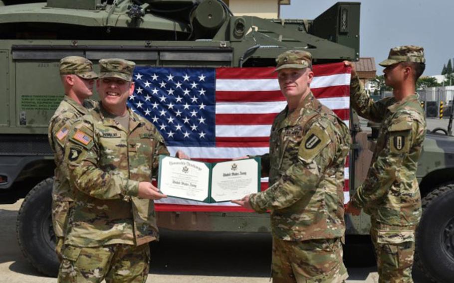 U.S. Army Garrison Humphreys Commander Col. Michael Tremblay administers the oath of reenlistment to 1st Signal Brigade NCO Staff Sgt. Christopher Owens, at the 304th Expeditionary Signal Battalion Motor Pool, on Camp Humphreys, June 10. (Photo Credit: George Park, USAG Humphreys Public Affairs Intern)