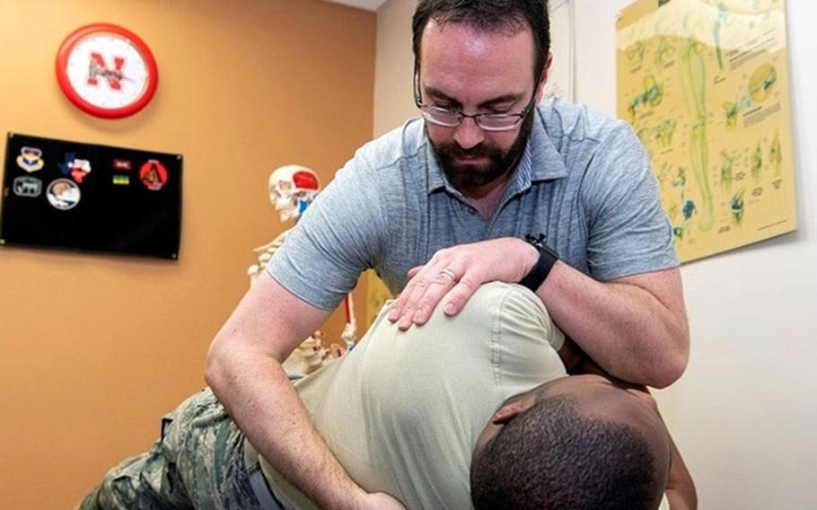 Jason Wheeler, 559th Medical Squadron physical therapist, attends to his duties at the Joint Base San Antonio-Randolph Physical Therapy Clinic. Neck and upper back pain are common complaints for teleworkers whose home office conditions are less than ideal.