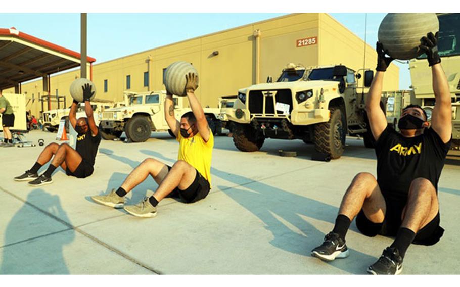 1st Armored Division Soldiers from the 4th Battalion, 70th Armor Regiment, 1st Brigade Combat Team perform medicine ball sit-ups during an early morning Holistic Health and Fitness (H2F) physical training session at Fort Bliss, Texas last August. As the nation slowly re-opened, soldiers were resuming battle rhythms while continuing to adhere to strict COVID-19 safety precautions, which can make training for combat-ready fitness and performance levels especially challenging. (U.S. Army photo by Jean Han)