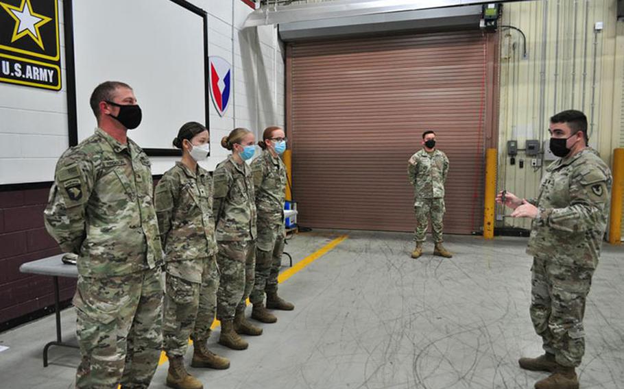 Lt. Col. Mark Sander, right, commander of the U.S. Army Medical Materiel Center-Korea, presents USAMMC-K coins to reserve Soldiers from the 401st Medical Logistics Company following training in August during Ulchi Freedom Shield, a joint exercise with Korean forces.