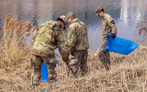 Soldiers assigned to the 210th Field Artillery Brigade at Camp Casey help clean up the banks of the Sincheon River in Dongducheon, South Korea, March 19, 2024.