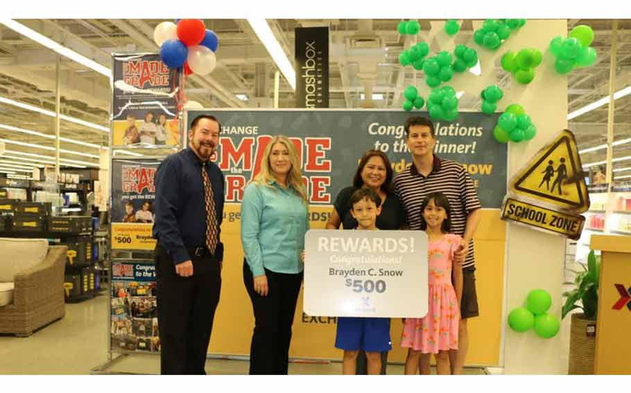 Brayden Snow accepts his You Made the Grade prize with his family, including parents Mark Snow and Orady Souksamlane.