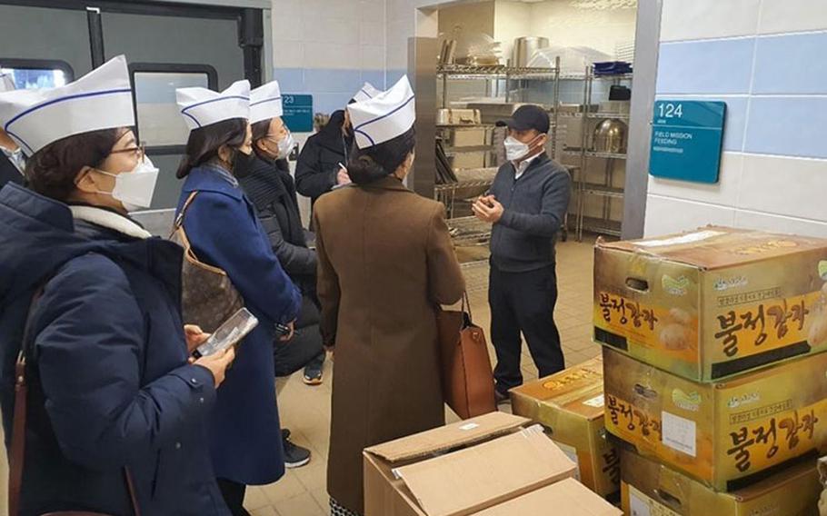 Sang Jang, Spartan Dining Facility operations manager, explains the storage area to the Gyeonggi-do school officials during a tour of the facility, Dec. 20. The school officials visited the facility to see the food operations, analyzing processes and procedures they may possibly implement in their schools. (U.S. Army Photo by Jason Om, USAG Humphreys Public Affairs Office)