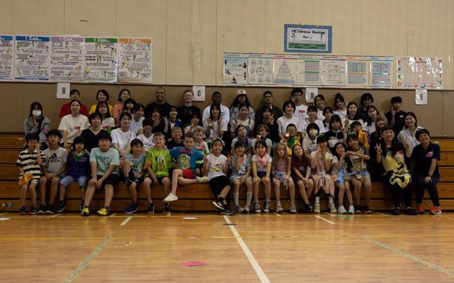 Participants pose for a group photo during a Host Nation Summer Program event on Camp Kinser, Okinawa, Japan, June 22, 2024. This program hosted a cultural exchange that included challenges and games for U.S. Marine volunteers from the Kinser Single Marine Program, local Okinawa volunteers from Kaiho High School and Lions Clubs International, students from Kinser Elementary School, and participants from Akata Town Children’s Club. This was the second year that local Okinawa participants joined the program hosted by Kinser Elementary School.