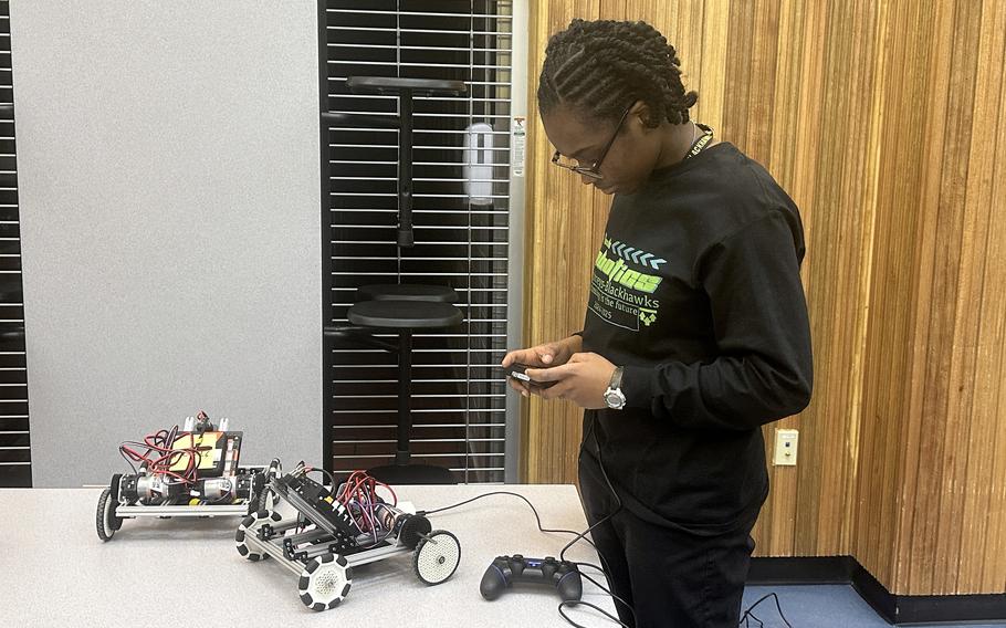 Abigail Loken works on robot car for Science Day in the Humphreys High School gym at Camp Humphreys.