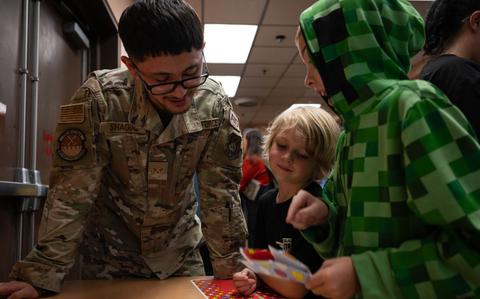 Photo Of U.S. Air Force Senior Airman Jonathan Shaoul, 51st Maintenance Squadron avionics journeyman, assists children in making a paper airplane during an event at Osan Air Base, Republic of Korea, Oct. 15, 2024.