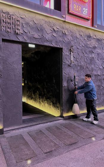 Army Sgt Eric Mendiola pulls the paintbrush to open the door of Kyochon Pilbang, Seoul, South Korea.