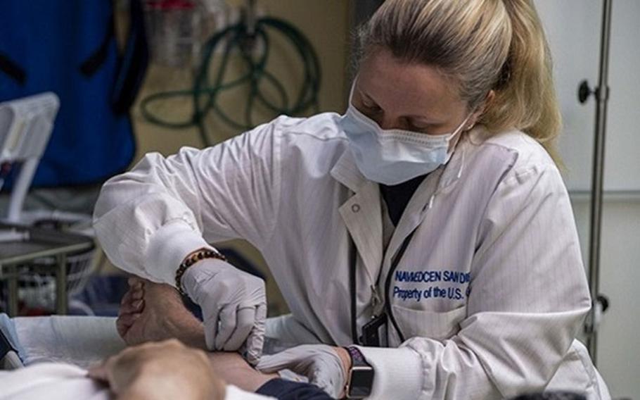 Michelle Pribble, Naval Medical Center San Diego's (NMCSD) lead nuclear medicine technologist, administers an IV to a patient before a positron emission tomography (PET) scan in the hospital's Nuclear Medicine Department in October 2020. A PET scan is used for revealing or evaluating conditions like heart conditions, cancers, and brain disorders (Photo by: Navy Seaman Luke Cunningham, Naval Medical Center San Diego).