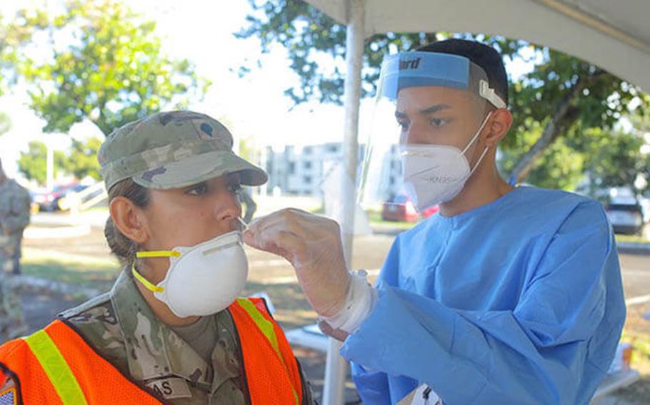 Coperal Jovan Pabon Centelles from Joint Task Force - Puerto Rico performs a COVID-19 test to Specialist Keyleen rentas at Bayamon Regional Hospital, Puerto Rico, Jan. 19, 2022. JTF-PR and the Department of Health of Puerto Rico assembled a health care site to provide medical treatment and COVID-19 testing to ensure the citizens' health and safety. (U.S. Army National Guard photo by Sgt. Carlos Chabert)