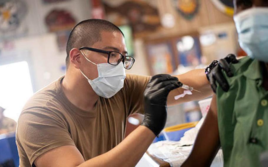 Navy Petty Officer 3rd Class Jemuel Macabali, from San Diego, Calif., gives the COVID-19 vaccine to staff at Camp Lemonnier, in Djibouti, Aug. 13, 2021.