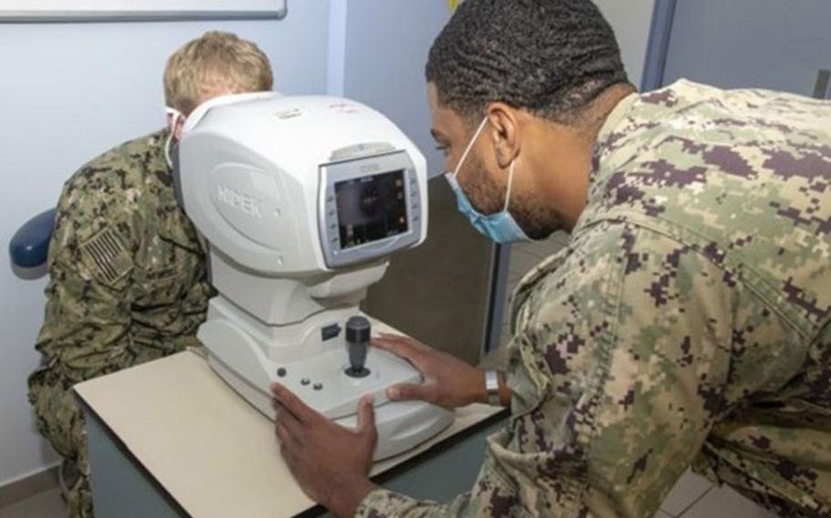 Navy Hospital Corpsman 3rd Class Jordan Belthrop (right) administers an eye exam on Navy Hospitalman Caleb Newbill at the Naval Support Activity Souda Bay’s, Branch Health Clinic on the island of Crete, Greece in Aug. 2020. (U.S. Navy photo by Joel Diller)