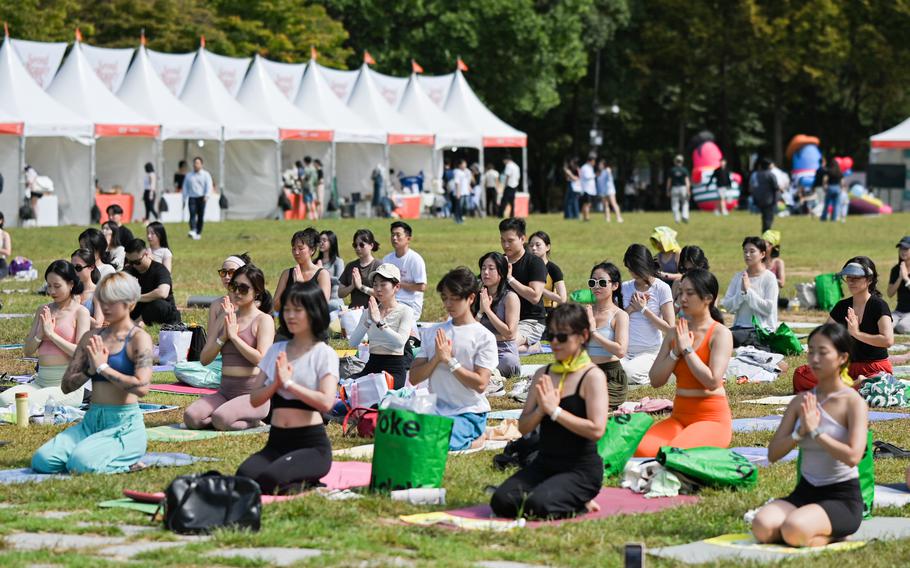 Participants are doing yoga on the lawn.