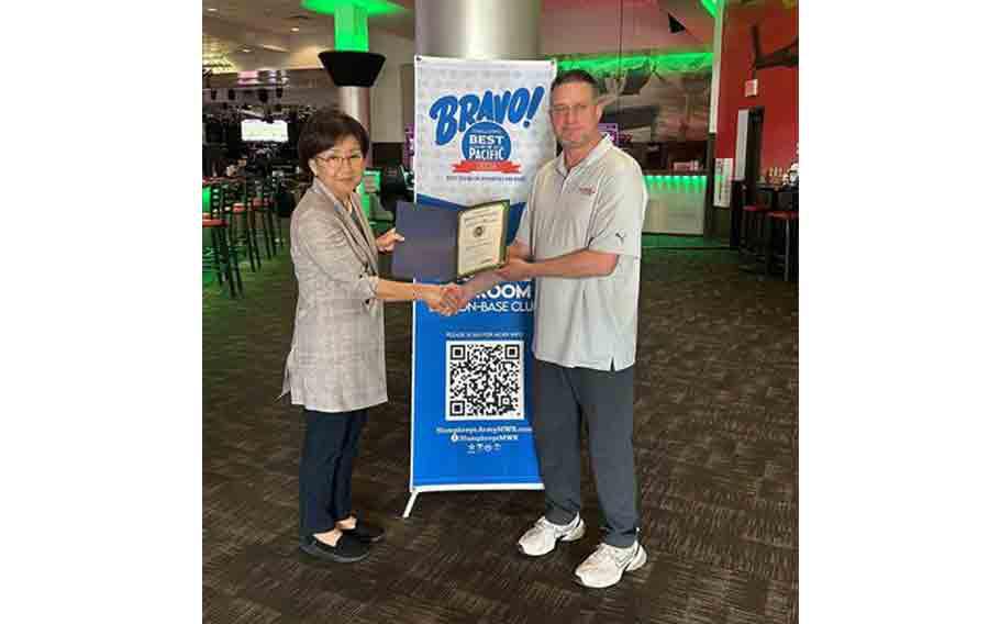 Stars and Stripes Pacific staff presents Best on-base clubs award to Flightline Tap Room staff.