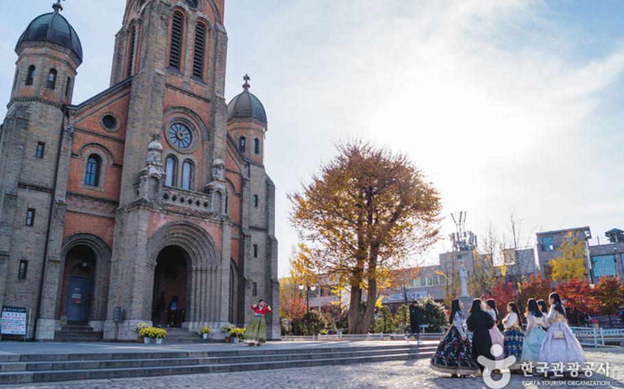 Some women stand in front of Jeonju Jeondong Catholic Cathedral.