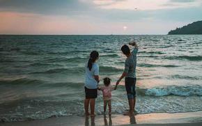 The family stands on the beach.