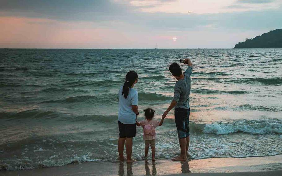The family stands on the beach.
