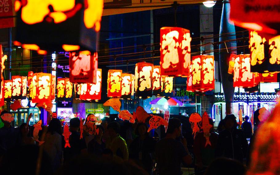 people enjoying a festival. many lanterns can be seen.
