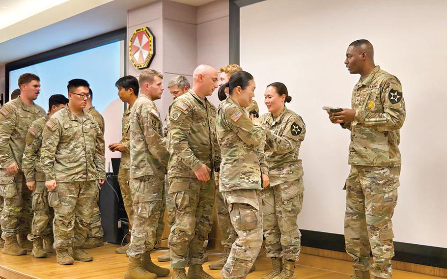 Military personnel participates in a patch ceremony.