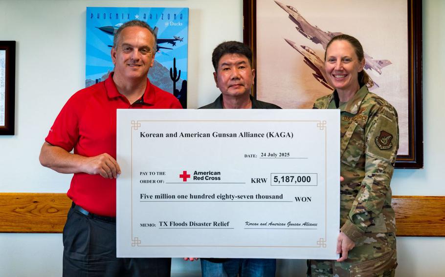 Brian Murnahan, American Red Cross Service to the Armed Forces Korea region regional program director, and U.S. Air Force Col. Kathryn “Wolf” Gaetke, 8th Fighter Wing commander, accept a donation for Texas flood relief efforts from Choi In-t’ae.
