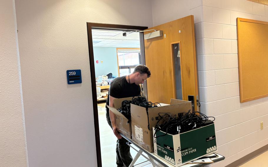 SGT Joseph Tate is moving classroom items. 