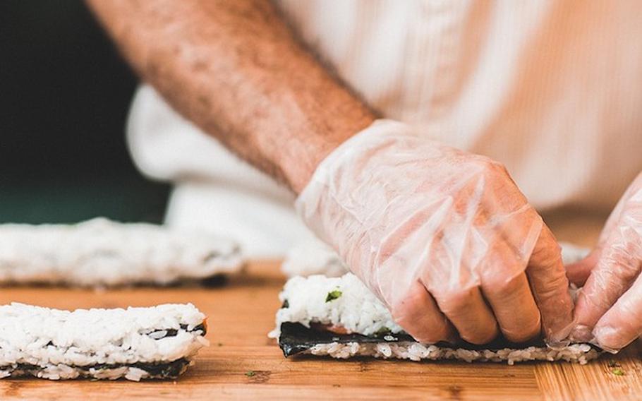 a chef wearing disposable gloves is cooking.