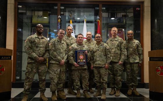 Eighth Army members pose with award.