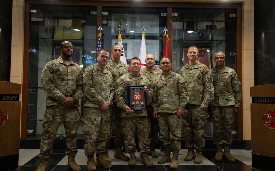 Eighth Army members pose with award.