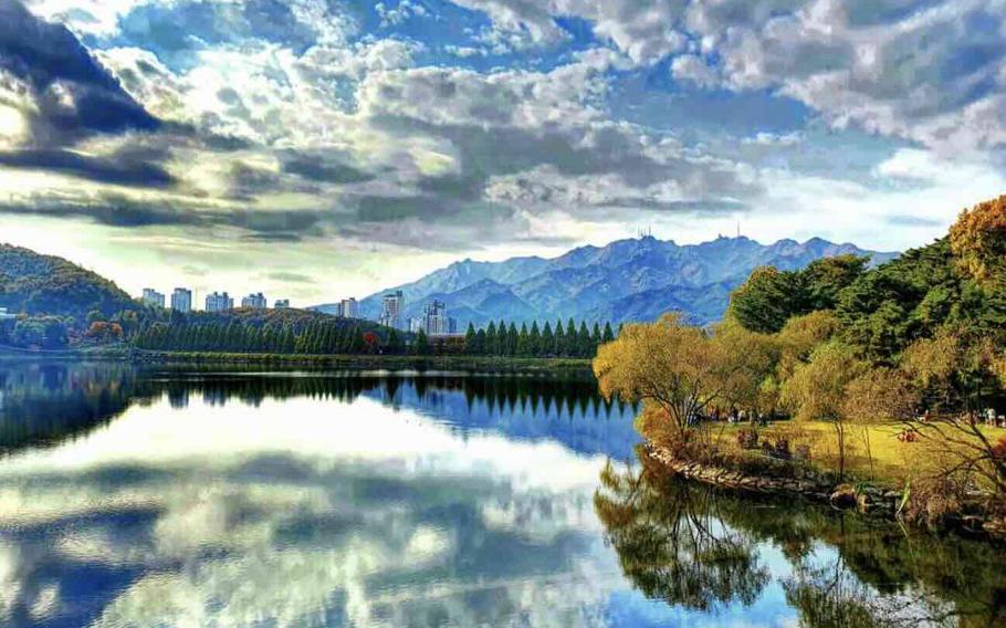 A lake or river reflects the white clouds.