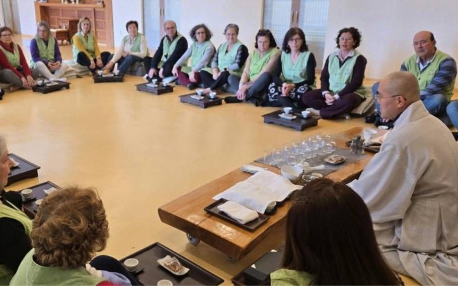 Visitors are having seat and enjoy tea time with monks.