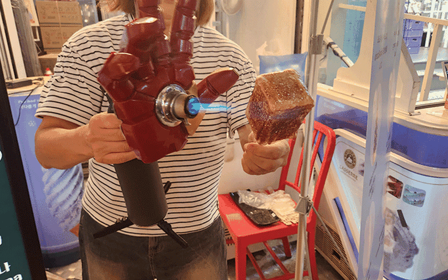 A staff member burns the surface of a Marshmallow Ice Cream.