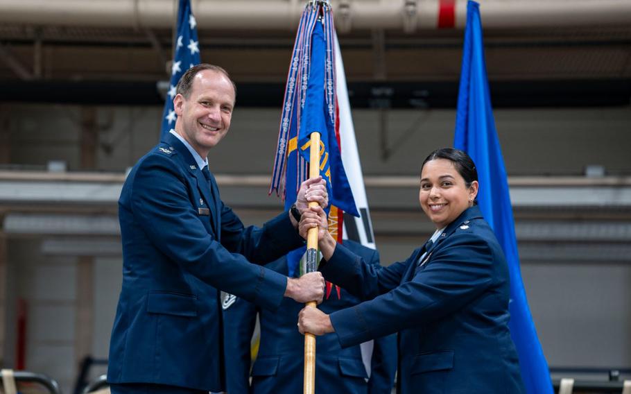 U.S. Air Force Col. Trigg Randall, left, 515th Air Mobility Operations Group commander, passes the guidon to Lt. Col. Diana Halferty, incoming 731st Air Mobility Squadron commander, during a Change of Command ceremony.