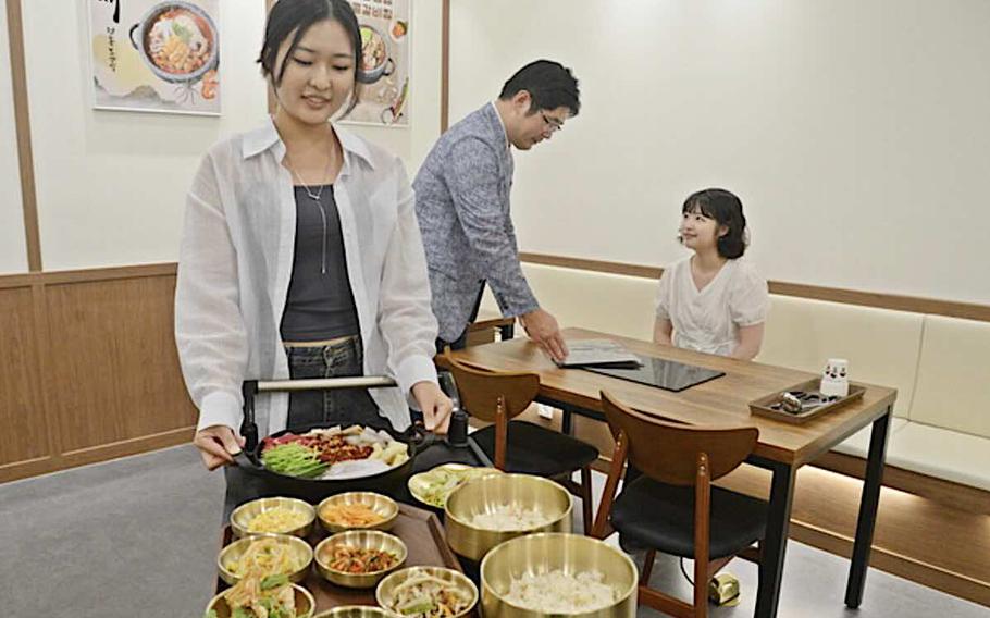 Three people prepare to eat.