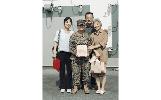 Photo Of U.S. Marine Corps Sgt. Amelia Kang, a combat graphics specialist assigned to the 15th Marine Expeditionary Unit, and a native of Portland, Oregon, poses for a photo with her aunt, uncle and grandmother following her promotion ceremony aboard the amphibious assault ship USS Boxer (LHD 4) at Busan Naval Base, South Korea, Sept. 8, 2024. The 15th MEU was in South Korea conducting Exercise Ssang Yong 24 to strengthen the Republic of Korea-U.S. Alliance through bilateral, joint training, contributing toward combined amphibious capability in defense of the Korean Peninsula.