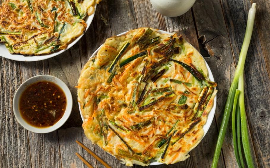 Chaeso jeon, sauce, and a leek on the table.