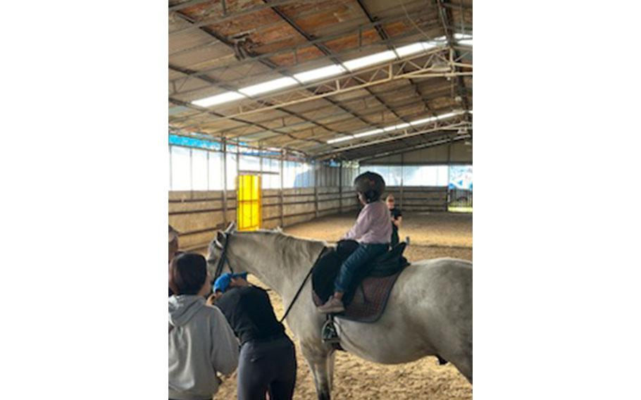 a kid enjyoing horse-riding.